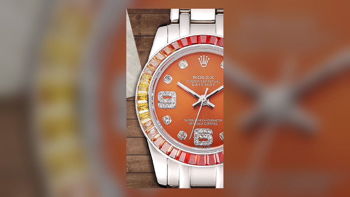 Close-up of a Datejust style watch with date window, gem-set markers and decorative bezel